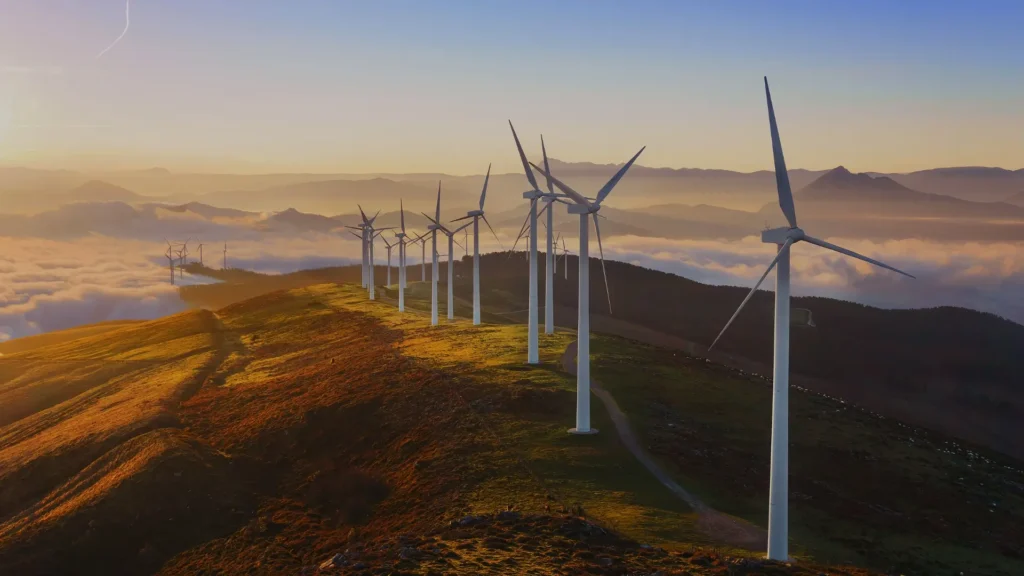 Wind turbines on a mountain at sunrise above a sea of clouds