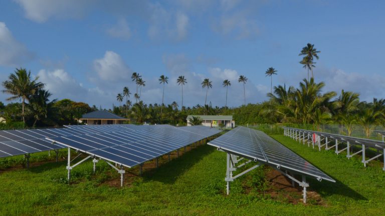 Solar panels on a tropical island with palm trees