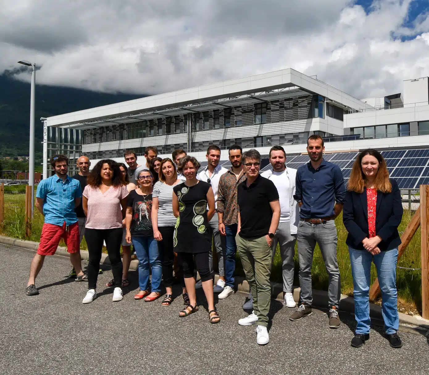 Steadysun team group photo outside INES in front of solar panels under cloudy sky