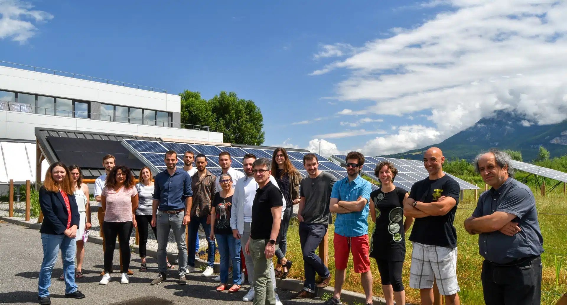 Steadysun team outside INES – Side view with solar panels and building under blue sky